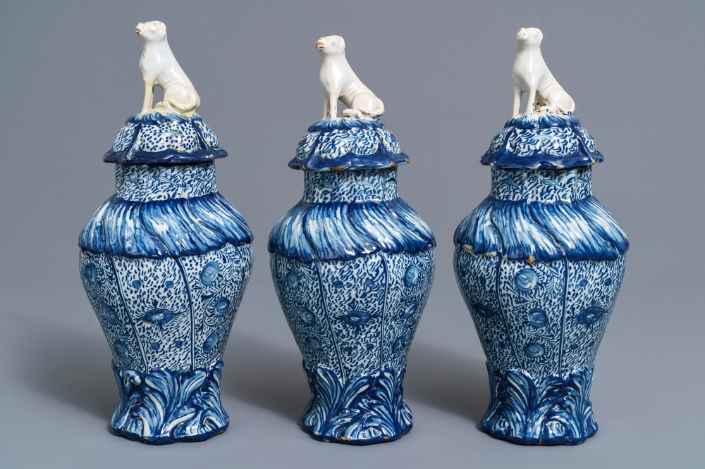 Three Dutch Delft blue and white dog-topped vases and covers, 18th C.