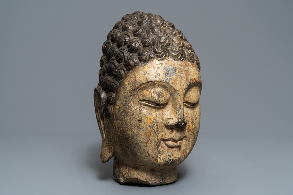 Une t&ecirc;te de Bouddha en pierre sculpt&eacute;e, traces de dorure et polychromie, Chine, Ming