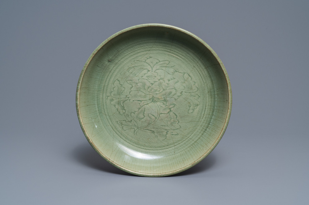 Een Chinese Longquan celadon schotel met onderglazuur pioenrozendecor, Ming