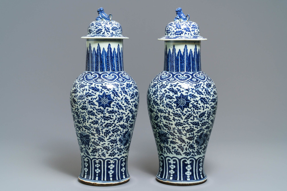 A pair of Chinese blue and white vases and covers with floral sprigs, 19th C.