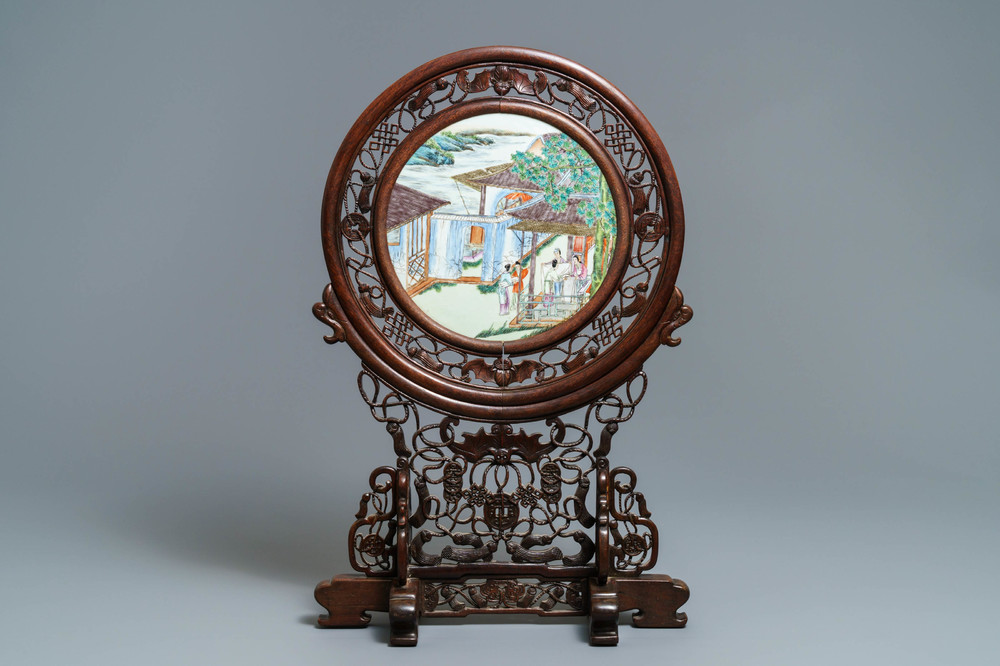 A Chinese carved wooden screen with a famille rose plaque, 19/20th C.