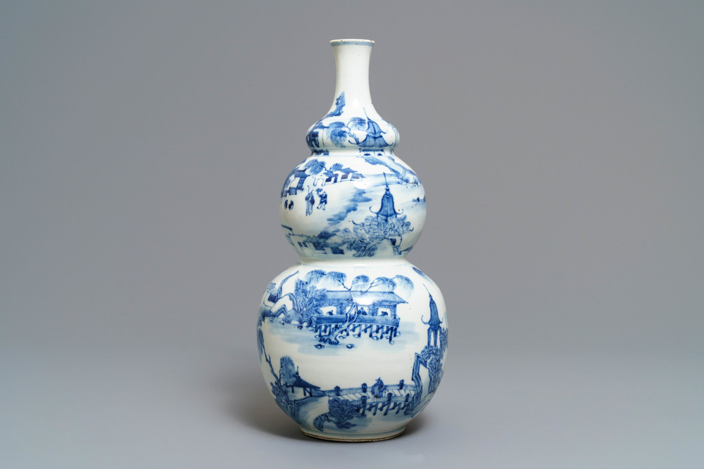 A Chinese blue and white triple gourd vase with circular landscape design, 19th C.