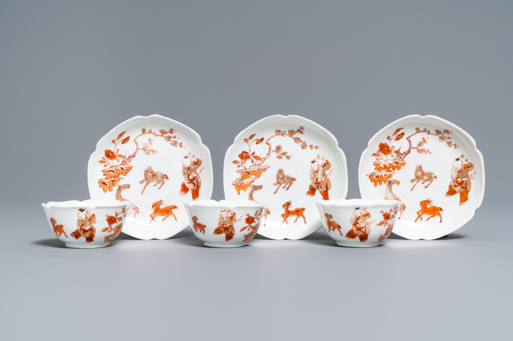 Three Chinese iron red eggshell cups and saucers with boys and goats, Yongzheng