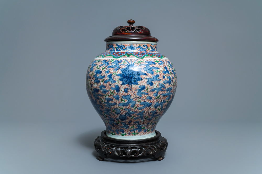 A Chinese wucai 'lotus scroll' jar with wooden cover and stand, Transitional period