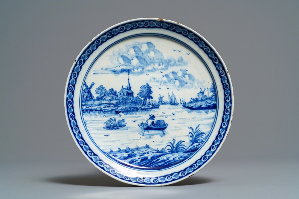 A Dutch Delft blue and white plate with a fine river landscape, 18th C.