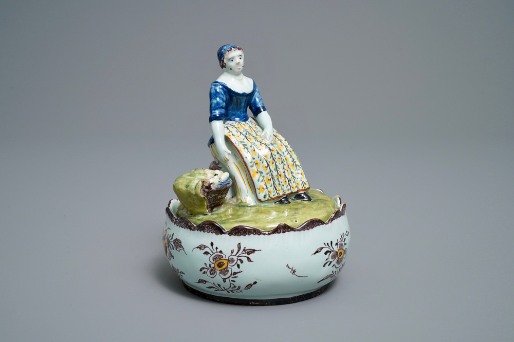 Un beurrier en fa&iuml;ence polychrome de Delft au couvercle en forme d'une marchande de l&eacute;gumes, 18&egrave;me