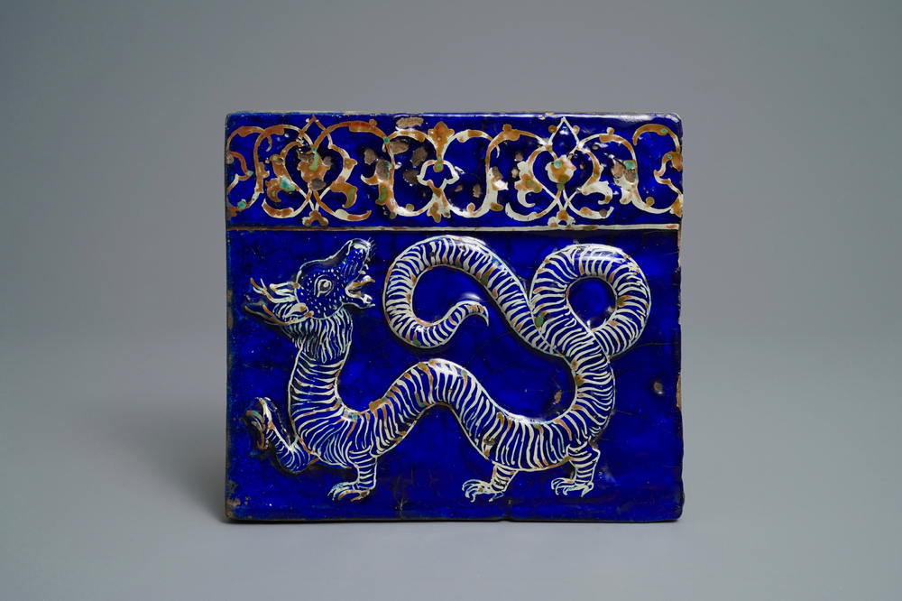 Un carreau en c&eacute;ramique persane &agrave; d&eacute;cor d'un dragon en relief, art qajar, Iran, 19&egrave;me