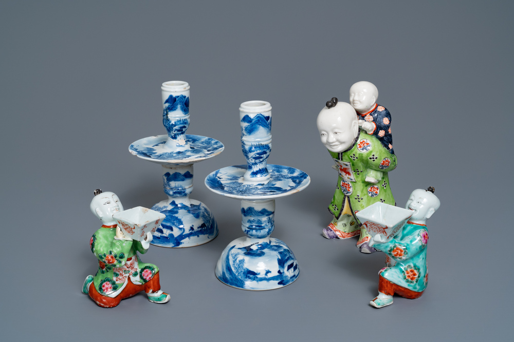 Een paar Chinese blauw-witte kandelaars en drie famille rose figuren van jongens, 19e eeuw