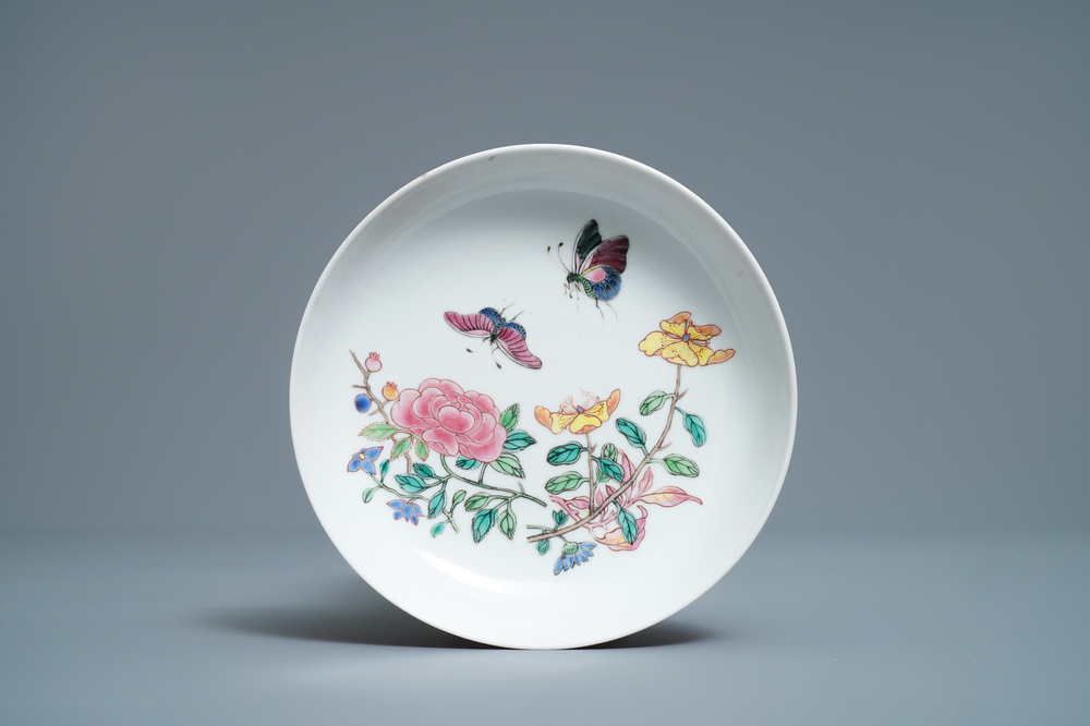 A Chinese famille rose 'ruby back' saucer dish with butterflies among flowers, Yongzheng