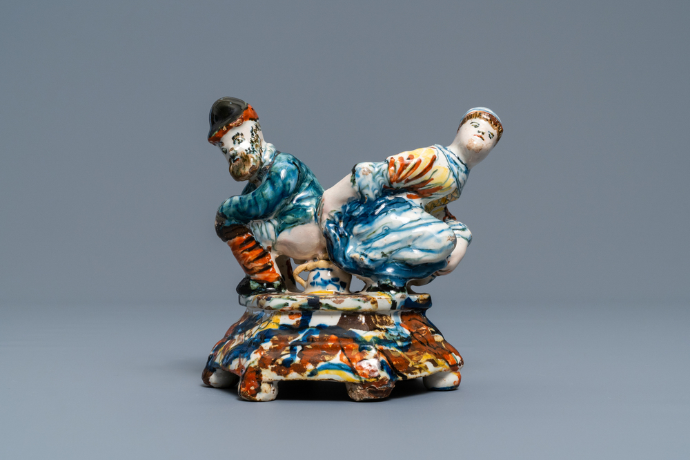 A polychrome Dutch Delft group of a man and a woman on a chamberpot, 18th C.