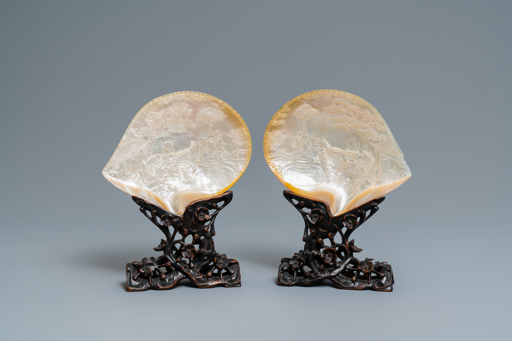 A pair of Chinese carved mother-of-pearl shells on wooden stands, 19th C.