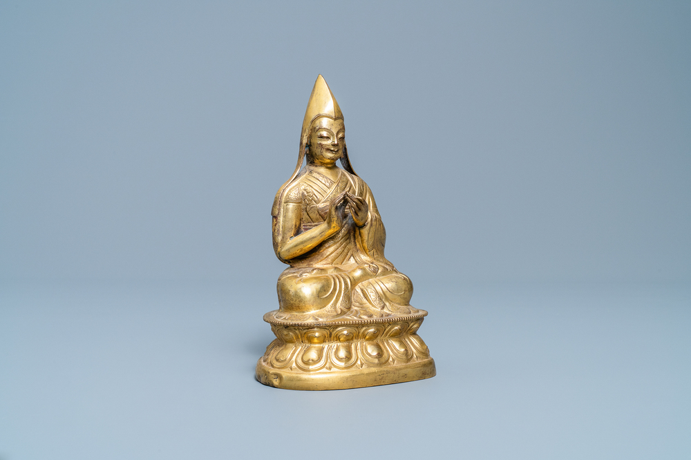 A Sino-Tibetan gilt bronze figure of a Lama, Ming