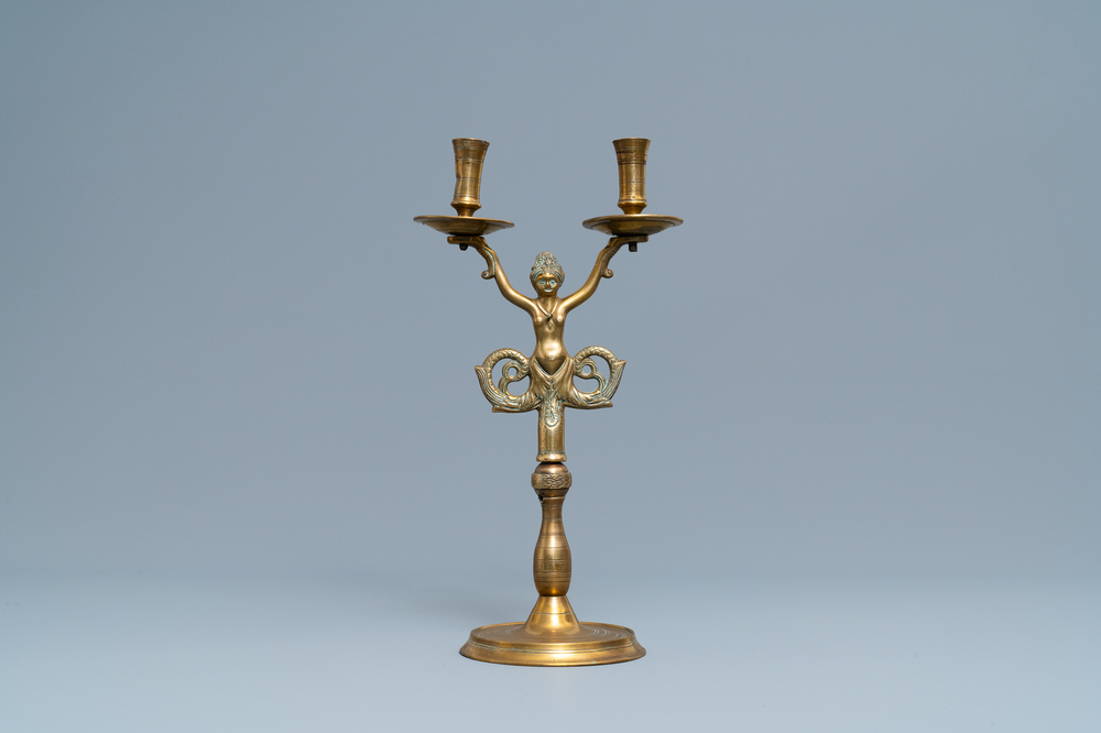 A large bronze candlestick with a siren with dolphin tails