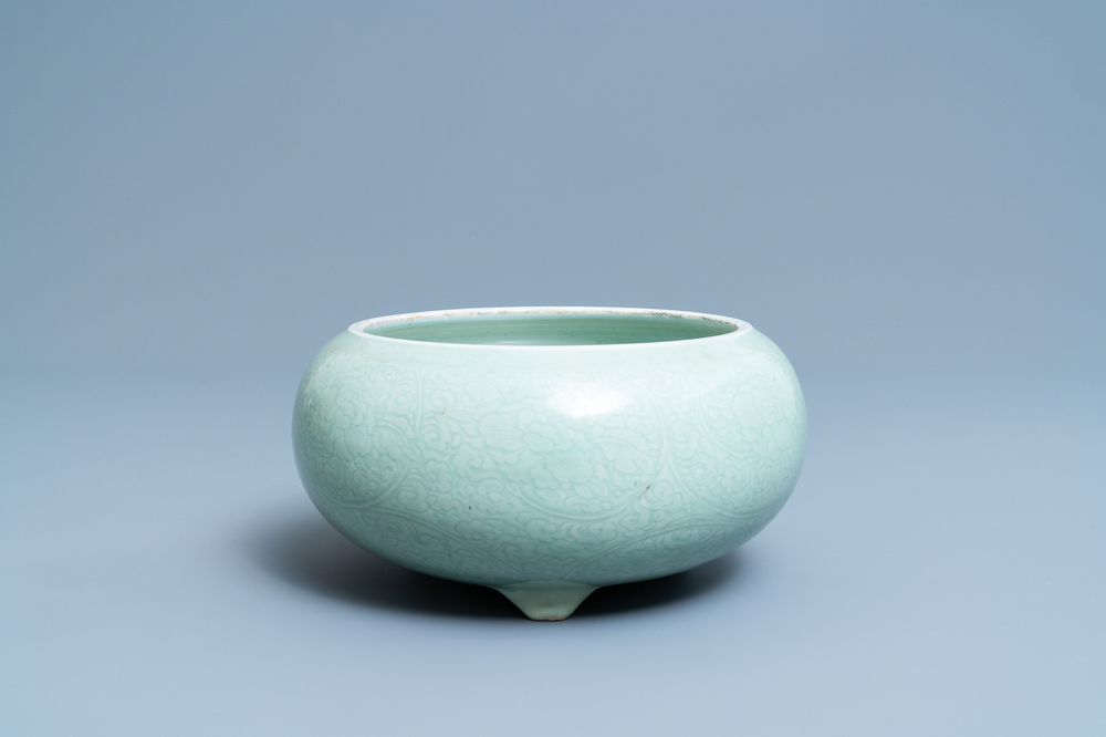 Een Chinese monochrome celadon driepotige wierookbrander met onderglazuur floraal decor, Kangxi