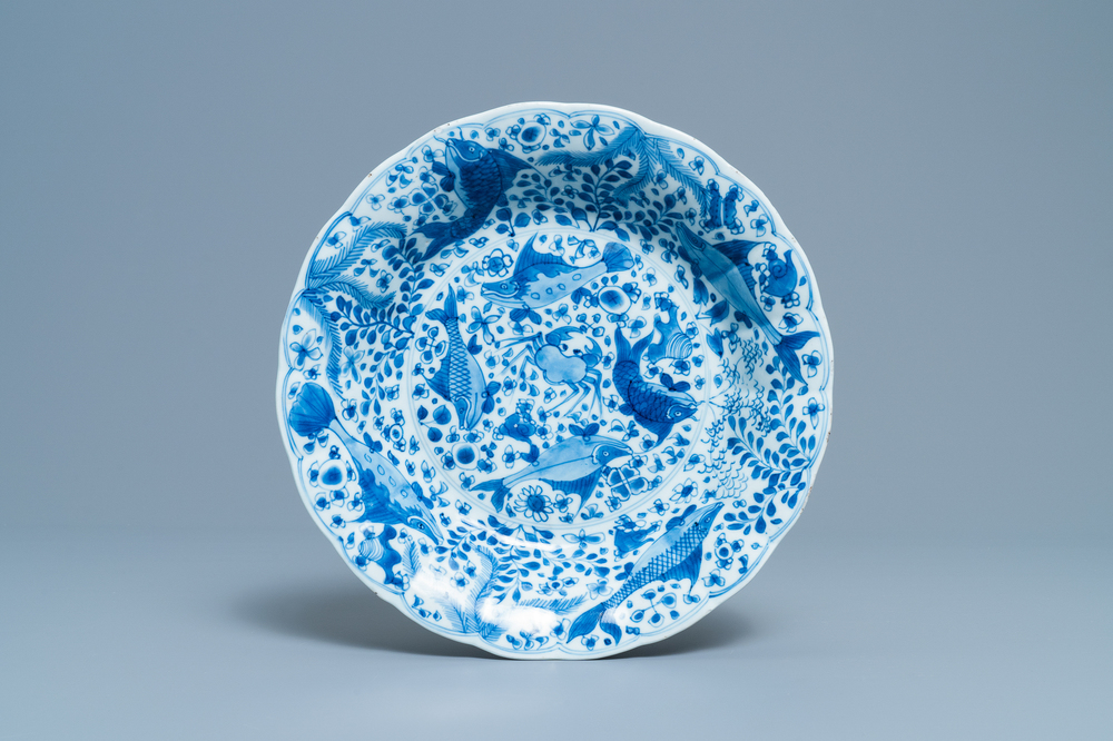 Un plat godronn&eacute; en porcelaine de Chine en bleu et blanc &agrave; d&eacute;cor de poissons, Chine, Kangxi