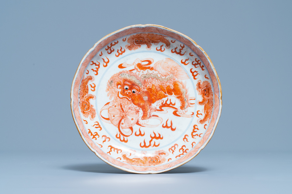 Une assiette en porcelaine de Chine en bleu, blanc et rouge de fer &agrave; d&eacute;cor de lions bouddhistes, marque de Qianlong, 19&egrave;me