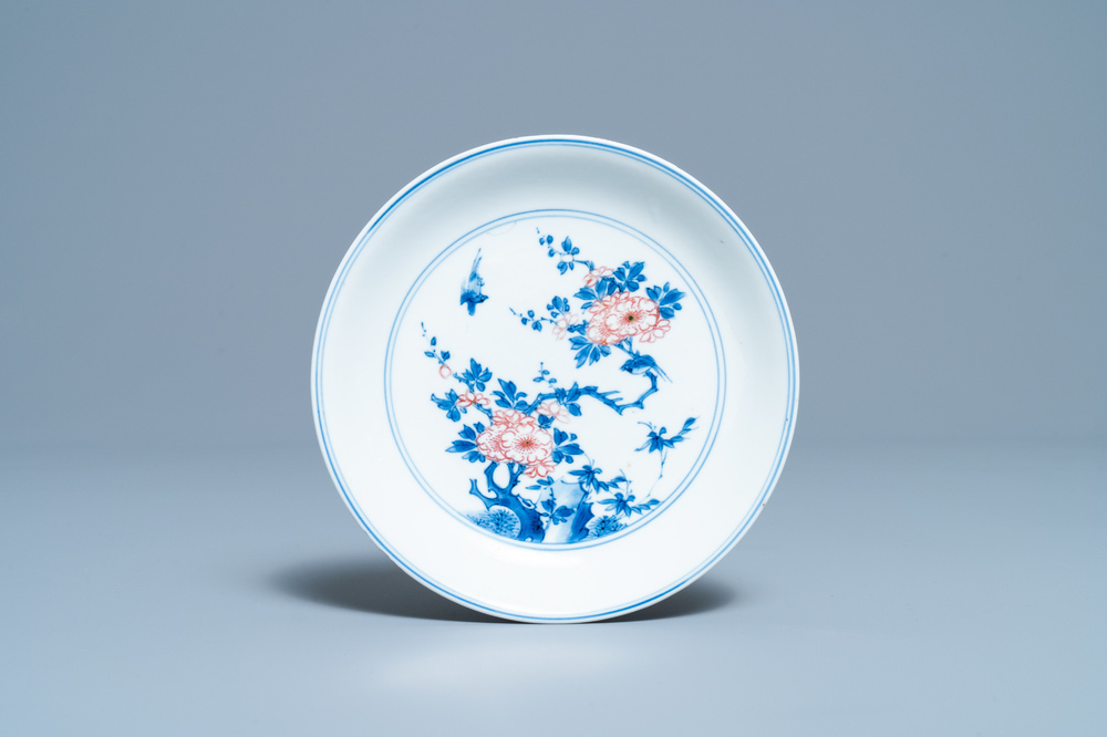 Een Chinees blauw-wit en koperrood bord met floraal decor, Kangxi