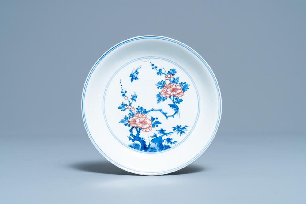 A Chinese blue, white and copper red saucer dish with floral design, Kangxi