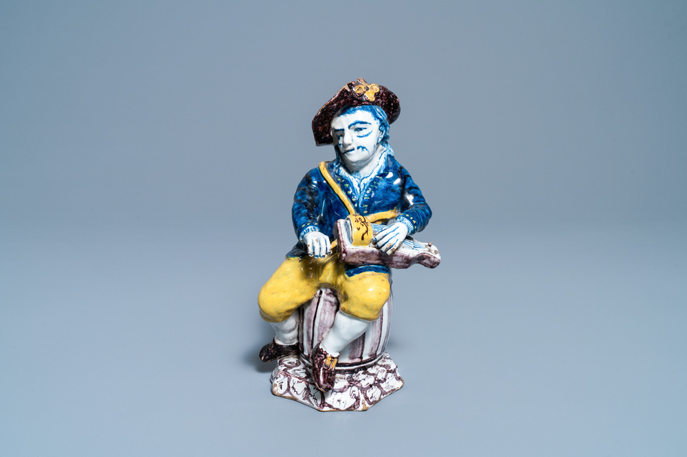 A polychrome Dutch Delft figure of a hurdy-gurdy player, 18th C.