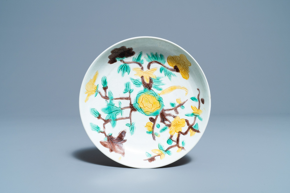A Chinese sancai-glazed plate with carved floral design, Kangxi