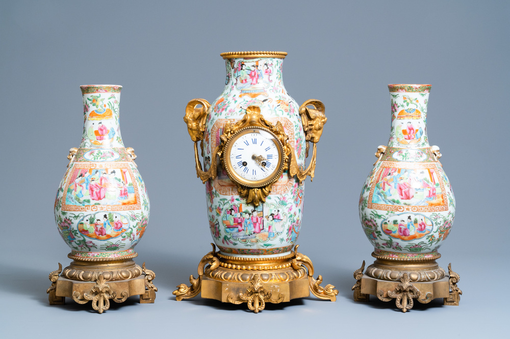 Une garniture de trois pi&egrave;ces en porcelaine de Chine famille rose de Canton mont&eacute;e en pendule en bronze dor&eacute;, 19&egrave;me