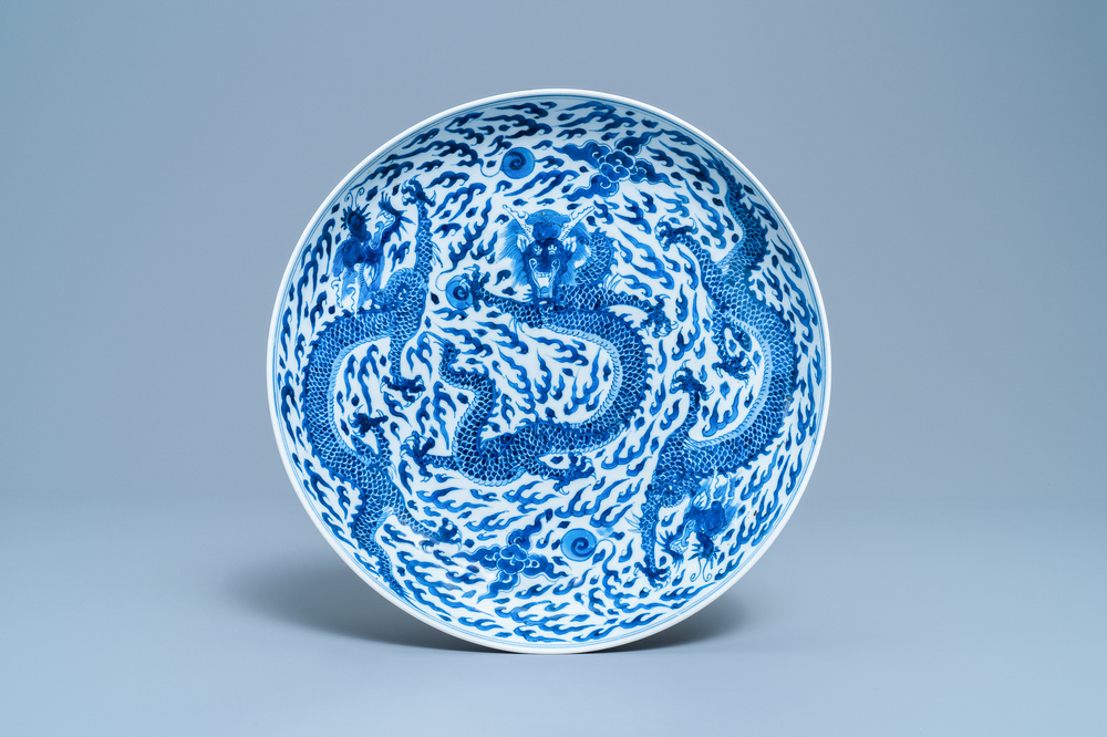 Un plat en porcelaine de Chine en bleu et blanc &agrave; d&eacute;cor d'un dragon, marque et &eacute;poque de Kangxi