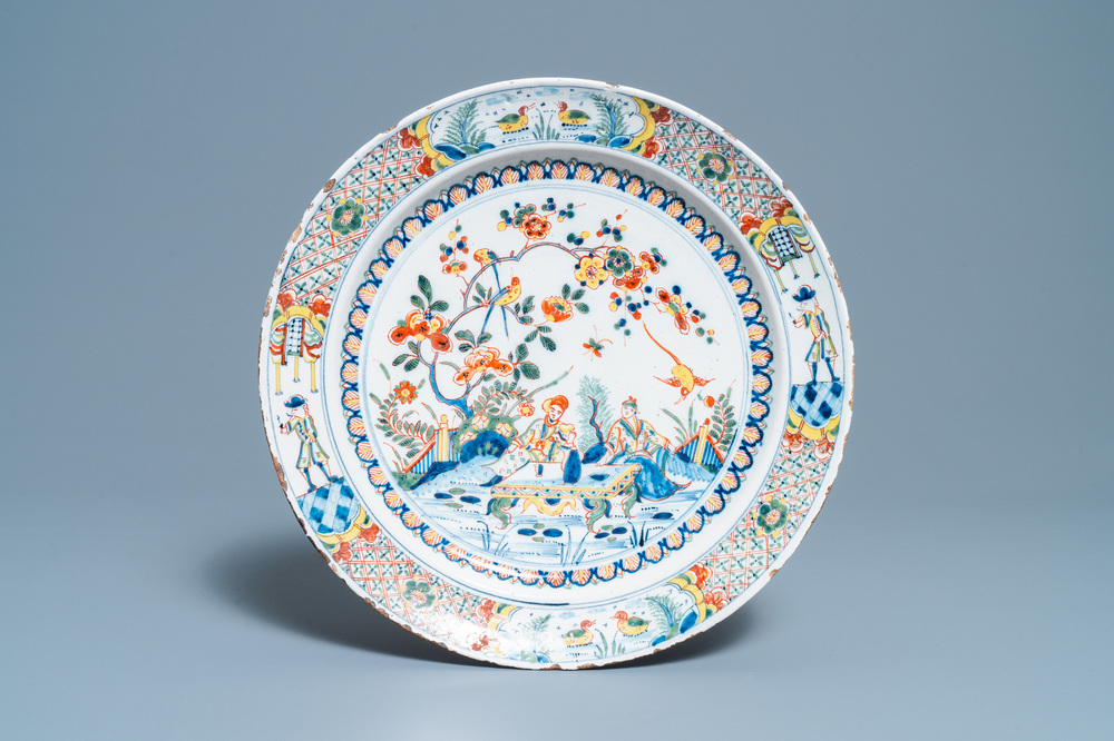 Een polychrome Engelse Delftware schotel met een chinoiserie theesc&egrave;ne, 18e eeuw