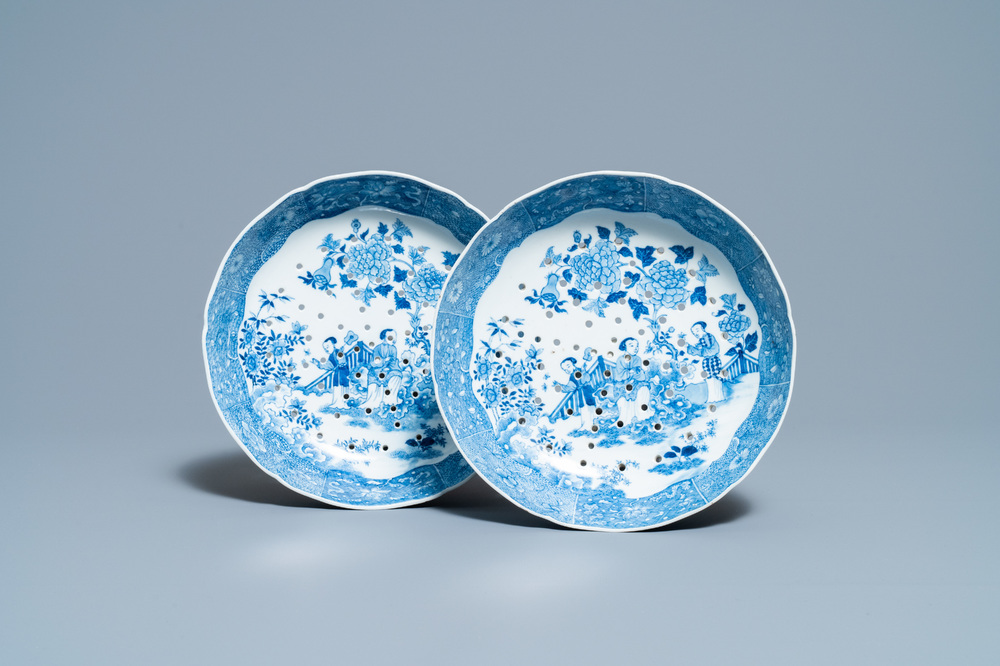 A pair of Chinese blue and white strainer dishes with ladies in a garden, Qianlong