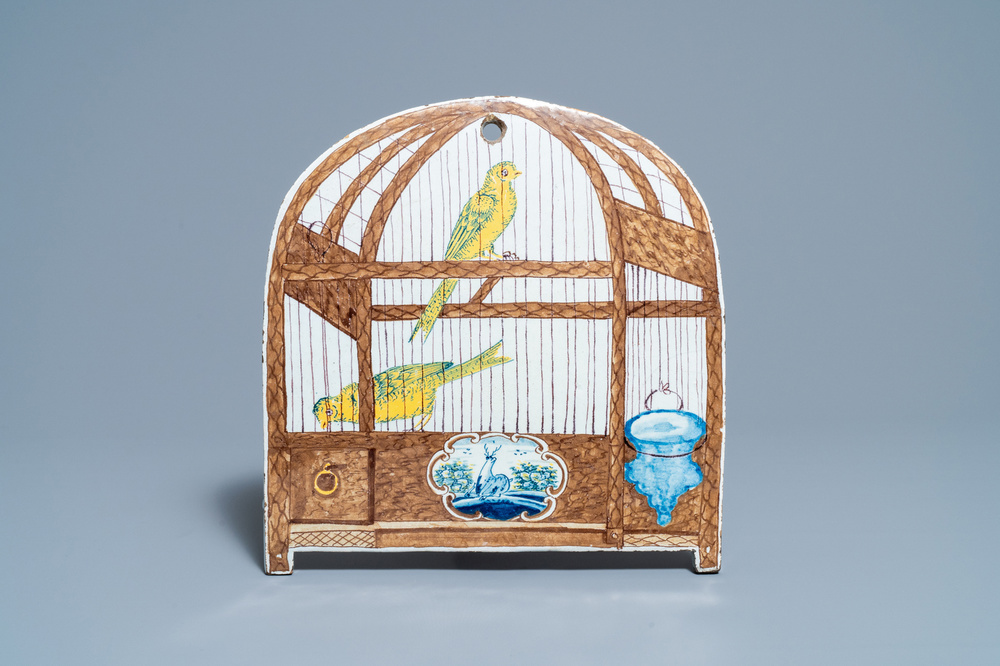 A rare polychrome Dutch Delft trompe l'oeil plaque with two canaries in a birdcage, 18th C.