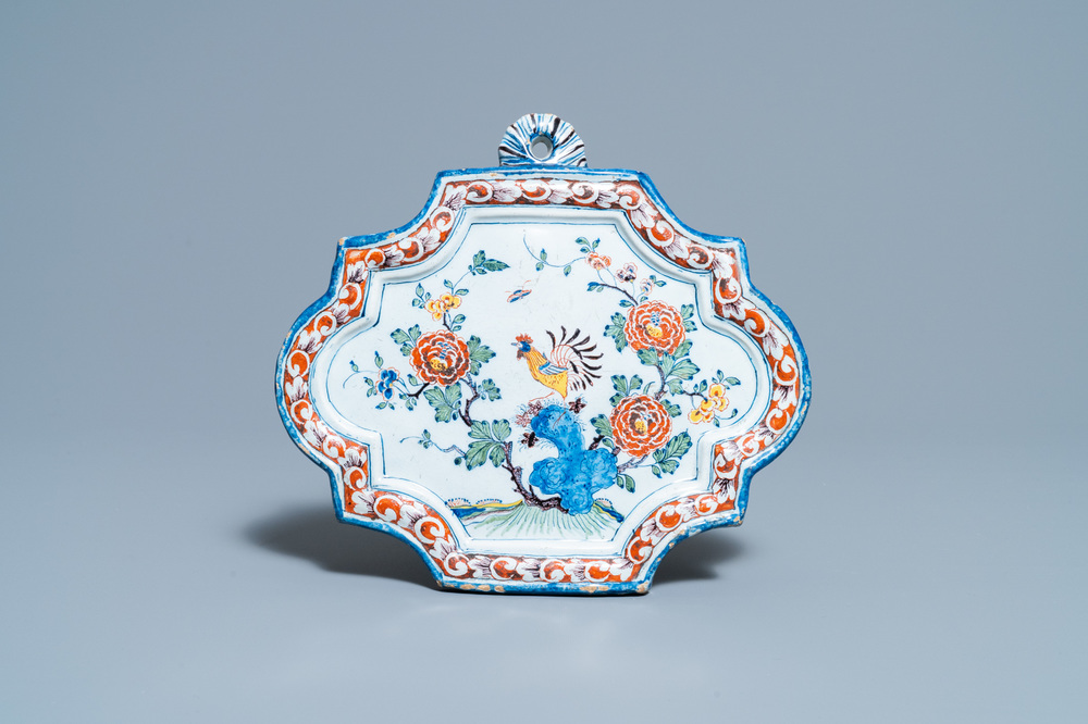 Une plaque en fa&iuml;ence de Delft polychrome &agrave; d&eacute;cor d'un coq, dat&eacute;e 1763