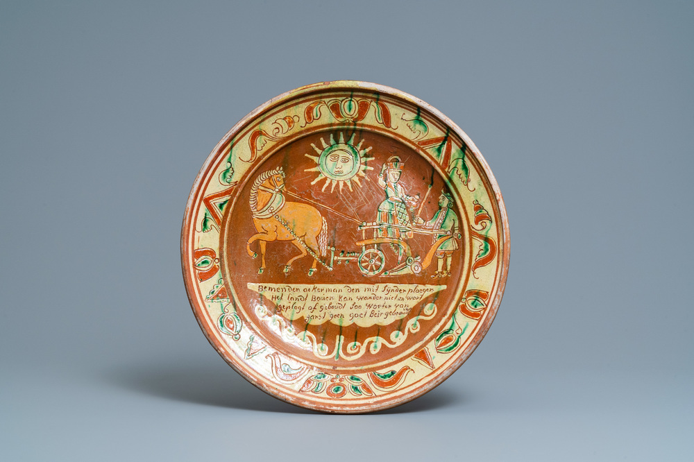 A German slip-decorated inscribed pottery dish with a ploughing farmer, Lower Rhine region, 2nd half 18th C.