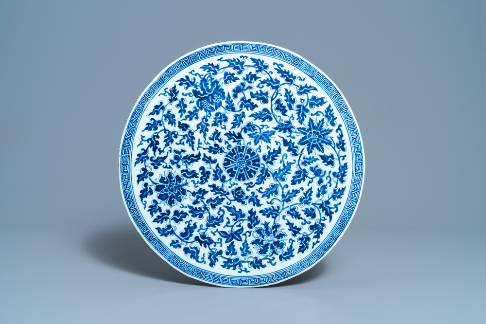 Een grote Chinese ronde blauw-witte plaquette met floraal decor, 19e eeuw