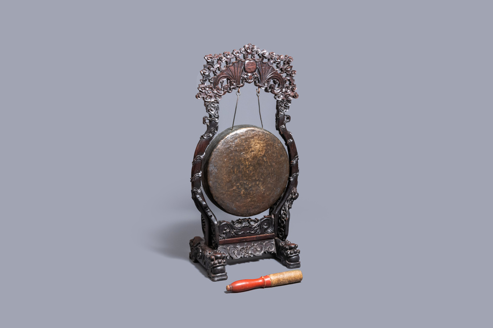 A Chinese bronze gong set in a carved wooden stand, 19th C.