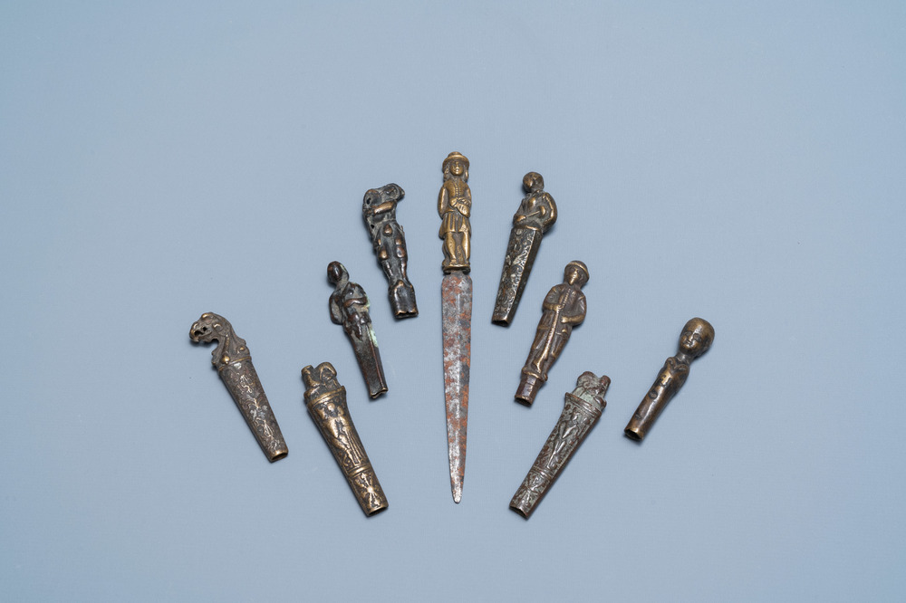 Nine bronze and brass knife handles including one with a knife, 16/18th C.