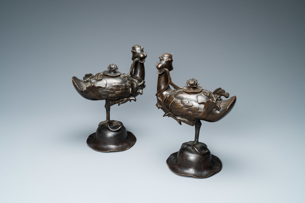 A pair of Chinese bronze censers modelled as ducks on a lotus flower, late Ming/early Qing