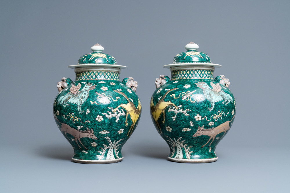 A pair of Chinese famille verte 'mythical animals' vases and covers, 19th C.