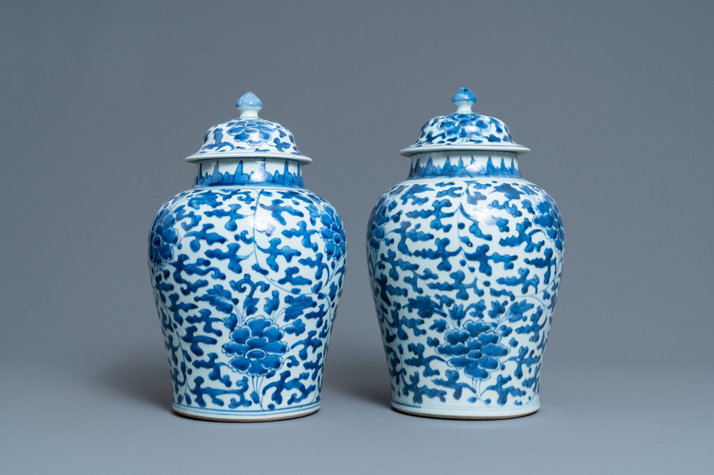 A pair of Chinese blue and white 'peony scroll' vases and covers, Kangxi
