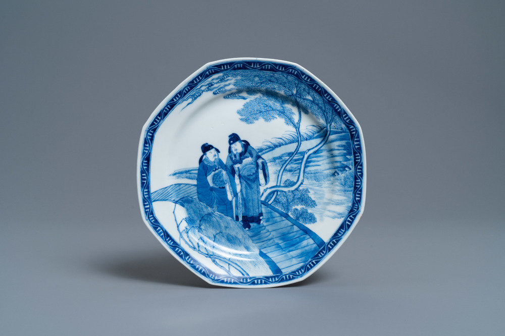 Een Chinees octagonaal blauw-wit bord met twee mannen op een brug, 'Fu hai cang zhen' merk, 19e eeuw