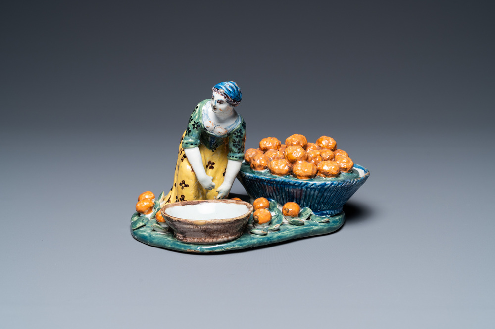 Een polychrome Delftse figuur van een fruitverkoopster met een kleine terrine, 18e eeuw