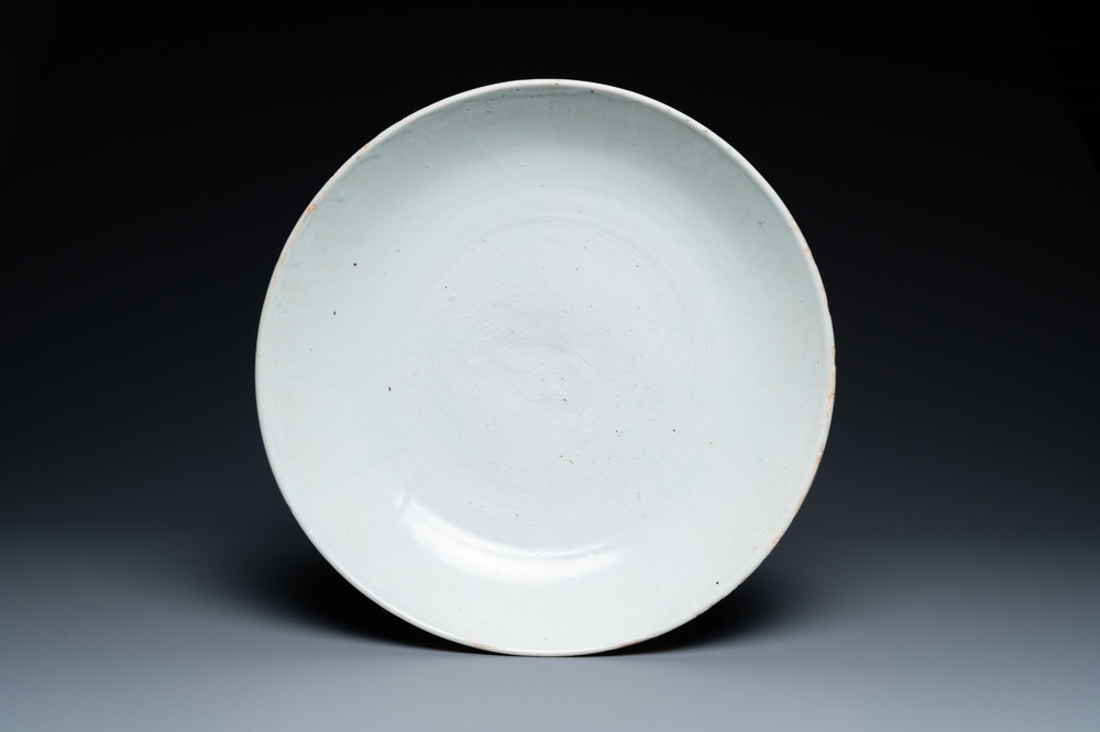 Un plat en porcelaine de Chine en blanc monochrome &agrave; d&eacute;cor incis&eacute; de deux ph&eacute;nix, Ming