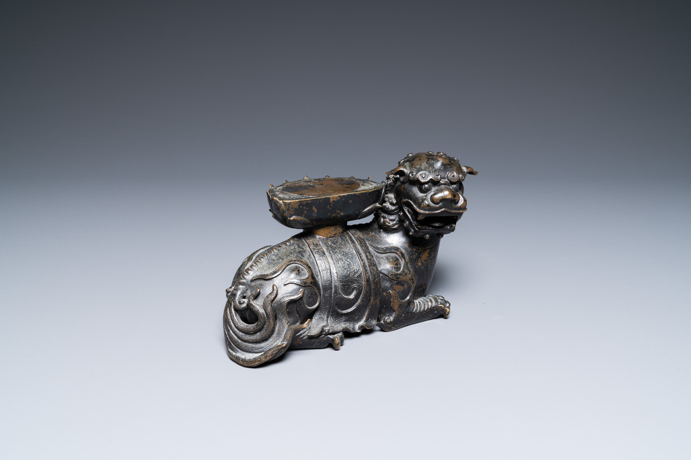 A rare Chinese bronze mythical animal 'Kaiming Shou' holding a lotus base, Ming