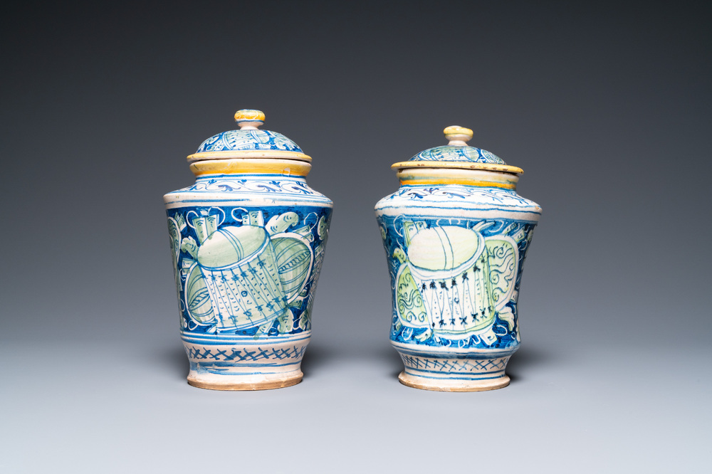 A pair of polychrome Italian maiolica covered albarelli with 'a trofei' design, Casteldurante, dated 1576