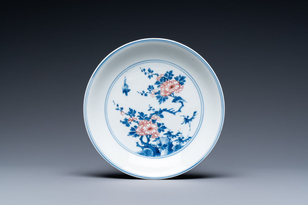 Een Chinees blauw-wit en koperrood bord met floraal decor, Kangxi