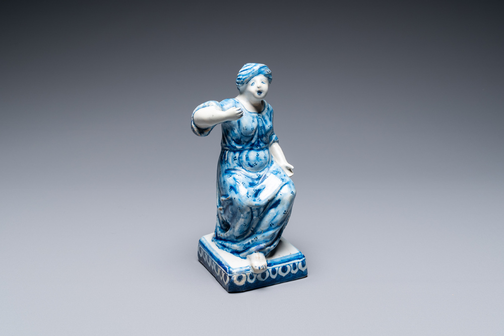 A Dutch Delft blue and white figure of a seated lady, 18th C.