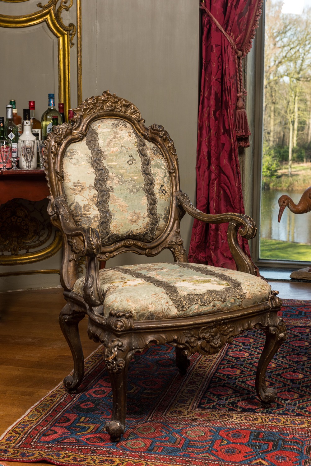 An Italian gilt carved wooden Louis XV armchair upholstered with silver brocade, 18th C.