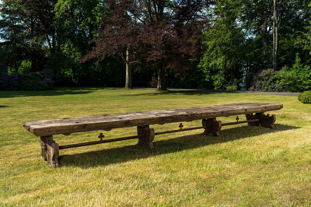 Een indrukwekkende lange houten tafel met uitsparingen uit de eetzaal van een weeshuis of klooster, 19e eeuw