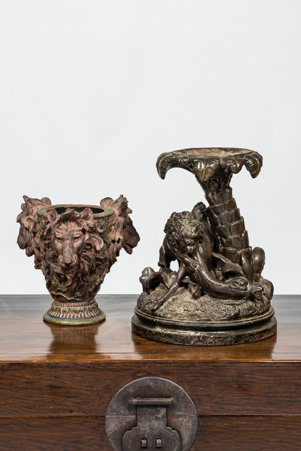 A faux bronze pottery group of a lion killing a camel and a patinated plaster jardini&egrave;re with lion's heads, 19th C.
