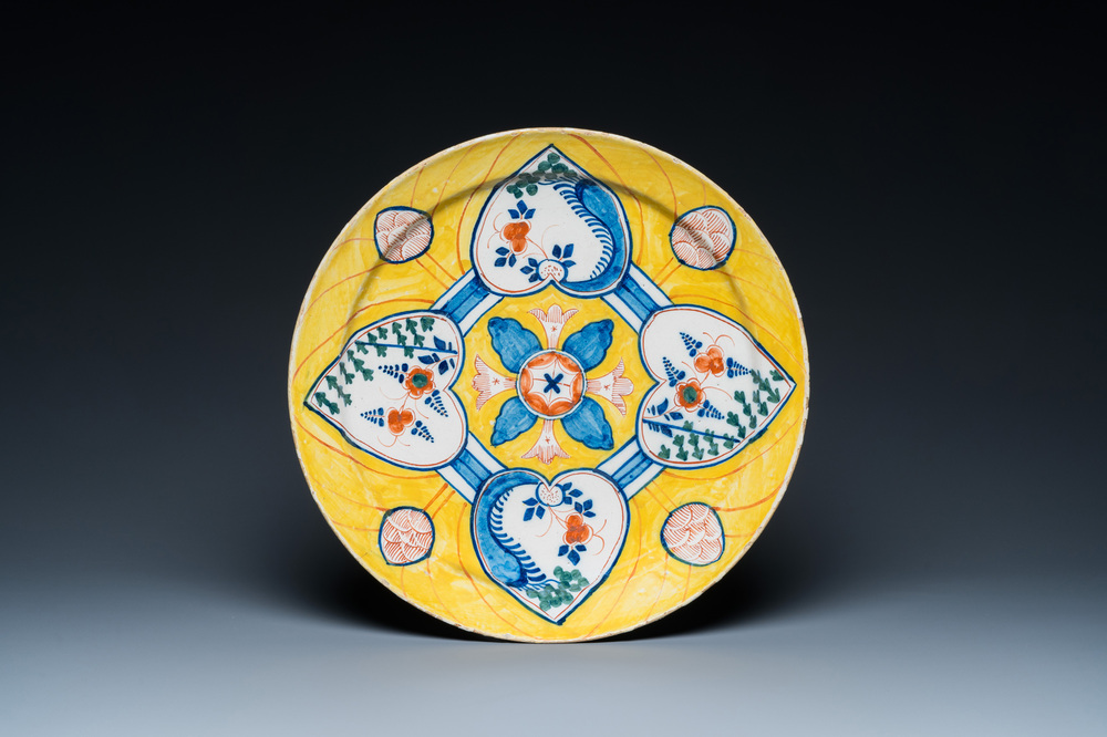 Un plat en fa&iuml;ence polychrome de Delft &agrave; fond jaune &agrave; d&eacute;cor aux quatre coeurs, 18&egrave;me