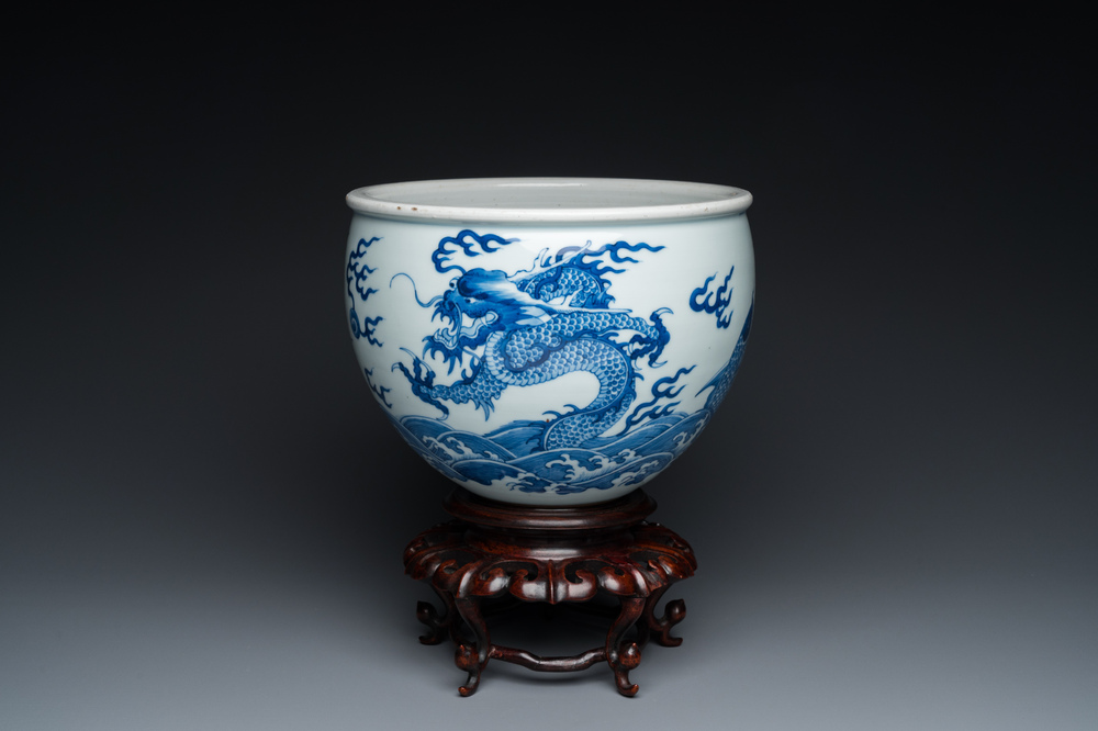 Een Chinese blauw-witte 'draken en karpers' jardini&egrave;re op houten sokkel, 19/20e eeuw