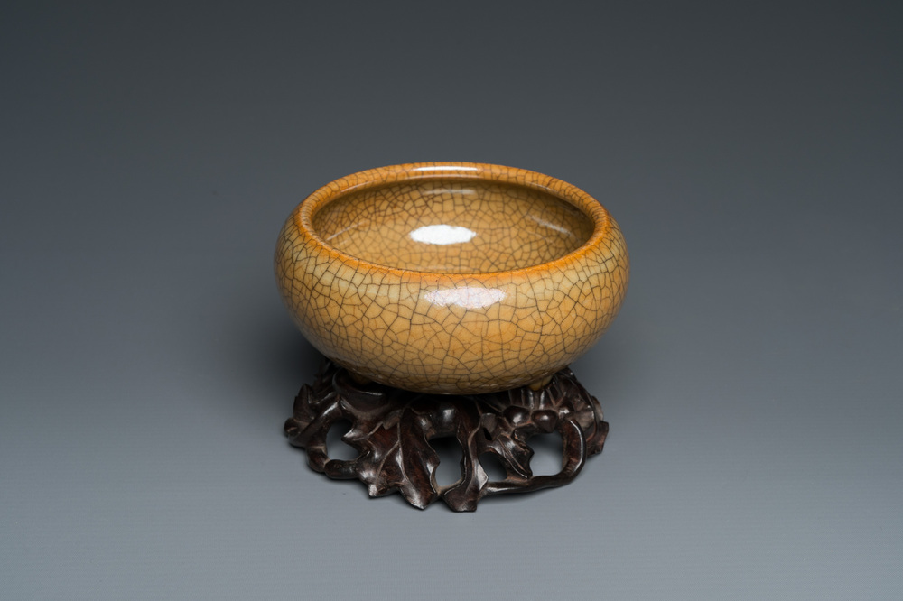 A Chinese crackle-glazed tripod censer on carved wooden stand, 19th C.